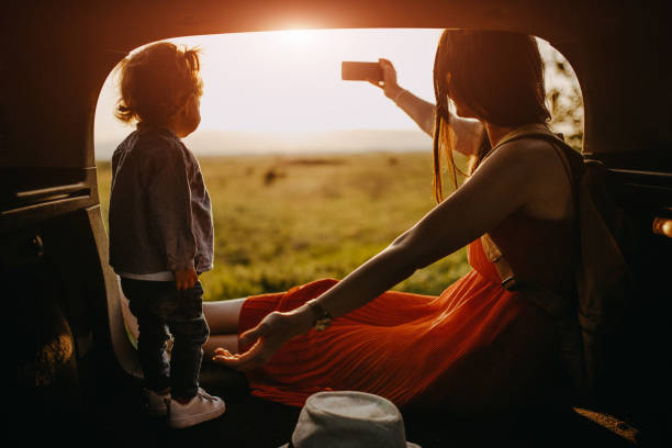istock Mother and daughter on a roadtrip taking selfie 957289332