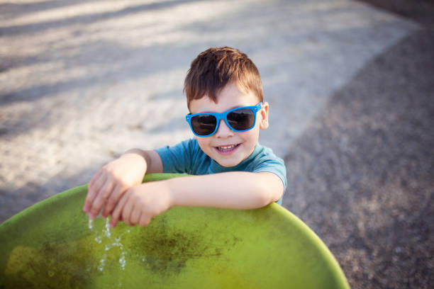 istock Happy little boy drinking water from fountain 957299040