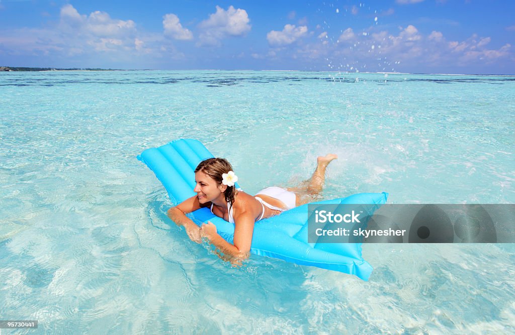 Happy woman floating on inflatable mattress.  Mattress Stock Photo