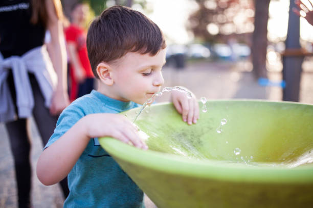 istock Happy little boy drinking water from fountain 957305258