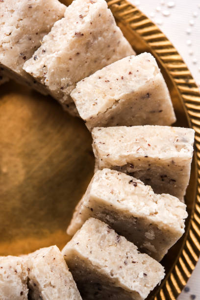 Fresh Nariyal Barfi / Coconut Burfi or Khobra Vadi, served in a bowl or plate over decorative background