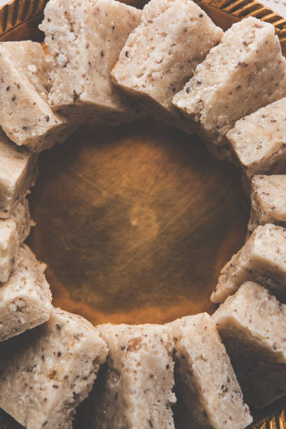 Fresh Nariyal Barfi / Coconut Burfi or Khobra Vadi, served in a bowl or plate over decorative background