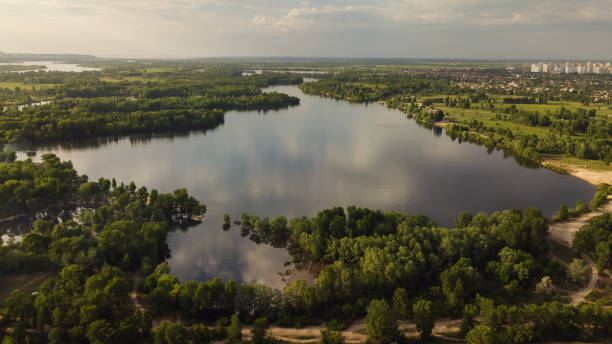 istock Aerial Drone footage, flying forward over a secluded lakes surrounded by dense forest, cottages can be seen. Sky and clouds reflected in the water. 957311474