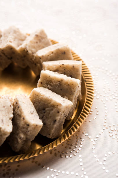 Fresh Nariyal Barfi / Coconut Burfi or Khobra Vadi, served in a bowl or plate over decorative background