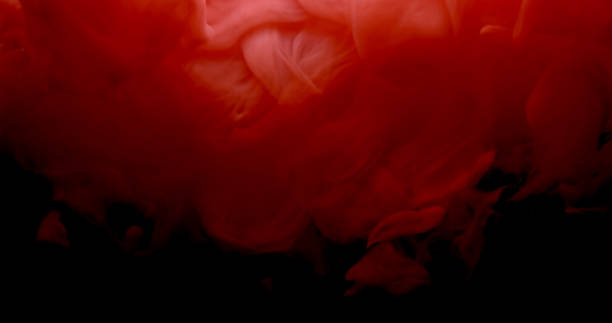 istock Red and white paint cloud spraying in water on black background. 957312358