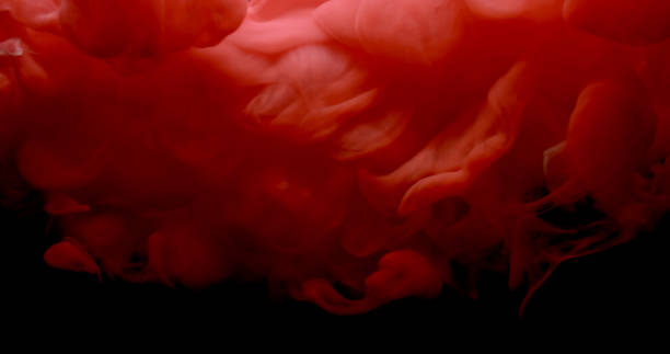 istock Red and white paint cloud spraying in water on black background. 957312362