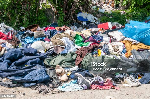 Pile Of Old Clothes And Shoes Dumped On The Grass As Junk And Garbage Littering And Polluting The Environment Stock Photo - Download Image Now