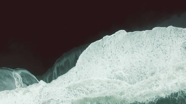 istock Ocean foam and black sand beach 957317330