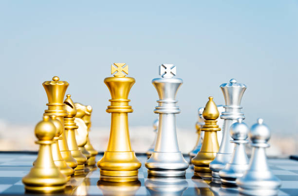 istock Golden and silver chess pieces on the board 957317954