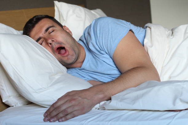 istock Hilarious looking man snoring loudly 957318598