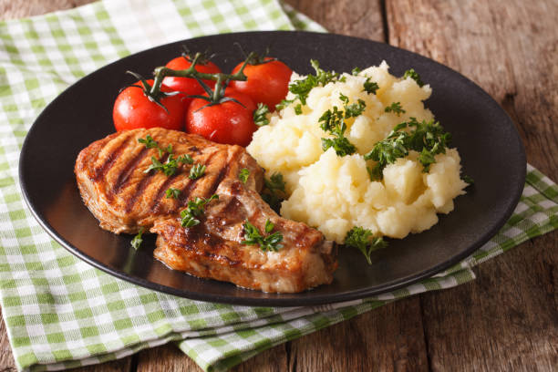 istock Grilled pork T-bone steak garnished with mashed potatoes close-up. horizontal 957322372