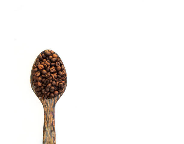 istock Coffee Beans in wooden spoon on white. 957327984