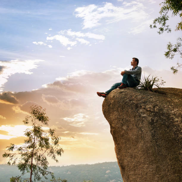 istock A man sitting on cliff enjoy the view 957329154