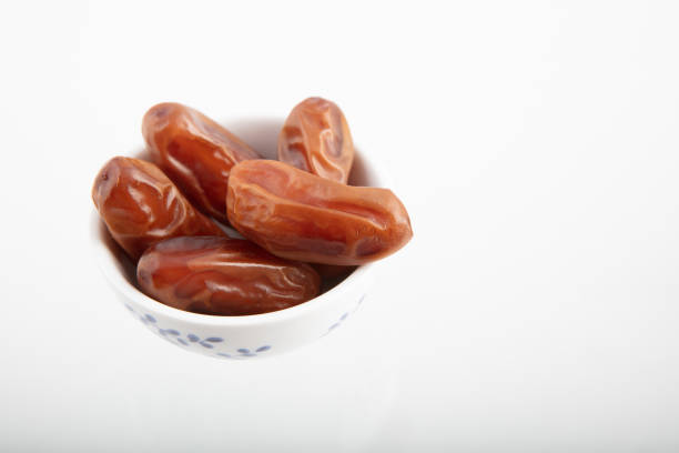Dried date fruit in bowl on white background , high angle view high quality image