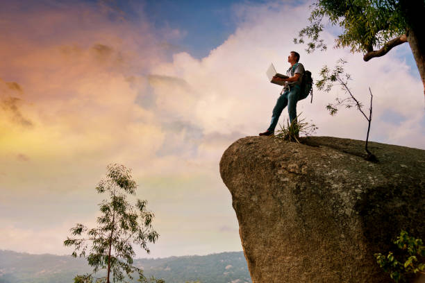 istock A man with a laptop standing on a rock 957331962