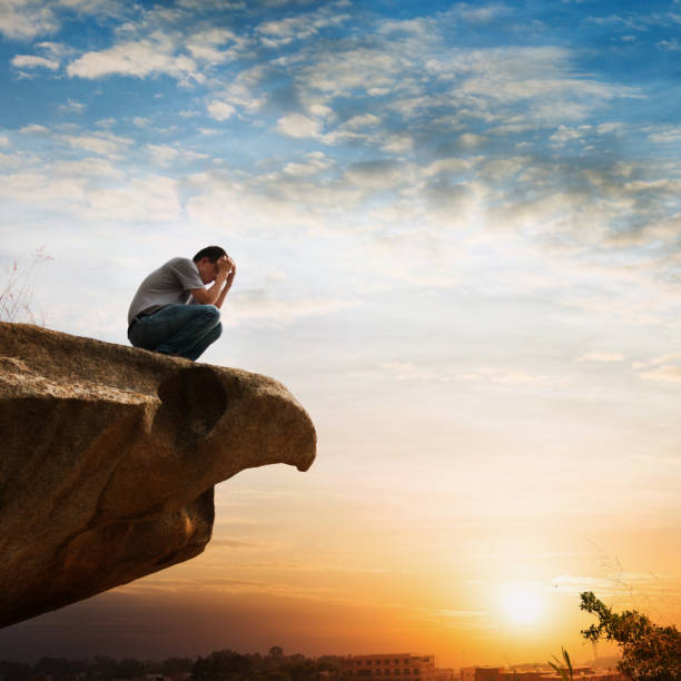 istock Man at the edge of a cliff and thinking 957332502