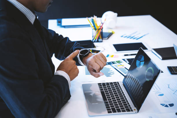 istock Business man looking at clock an waiting meeting in office. 957332510