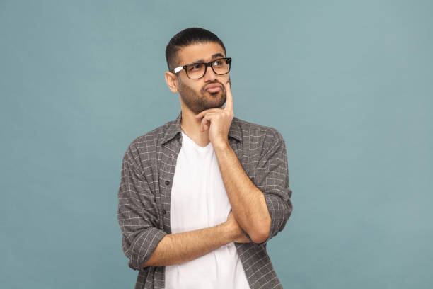 portrait of thoughtful handsome man with black glasses in casual style thinking. - business men humor macho imagens e fotografias de stock