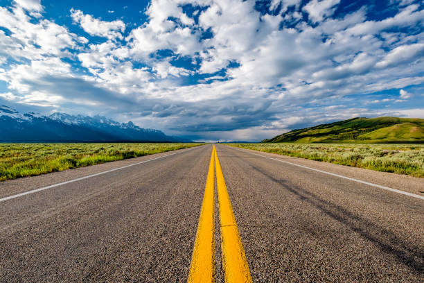 Empty open highway in Wyoming Empty open highway in Wyoming, USA straight stock pictures, royalty-free photos & images