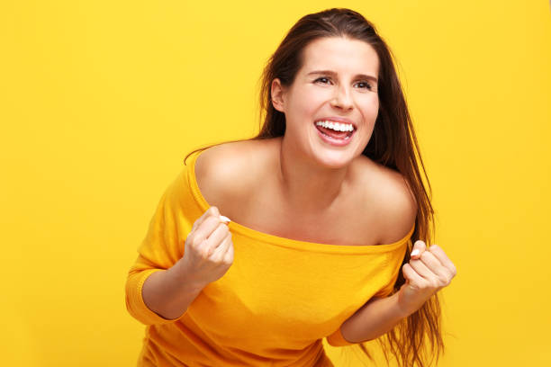 istock Woman against yellow wall background 957333906