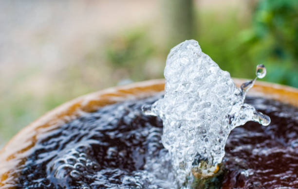 istock Water in small fountain flowing up high from pipe and form interesting different shape, it is captured in high shutter speed 957344760