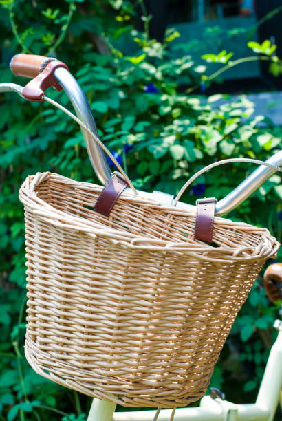 istock Weaved basket in front of foldable bicycle with plant background 957344780