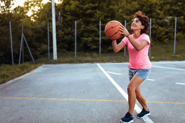 istock Mature woman playing basketball 957345660