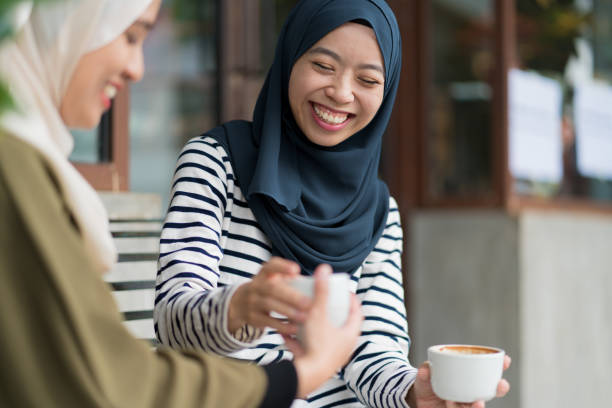 istock Friends sitting outside drinking coffee and chatting 957345724