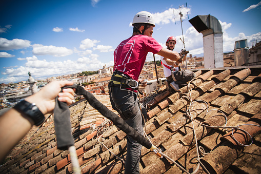 Manual workers in action on the roofs of Rome