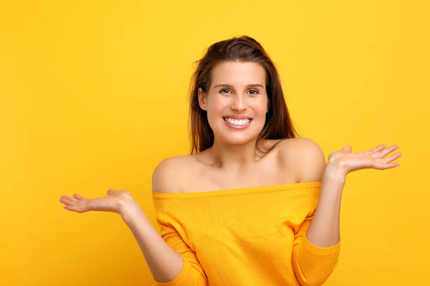 istock Woman against yellow wall background 957349600