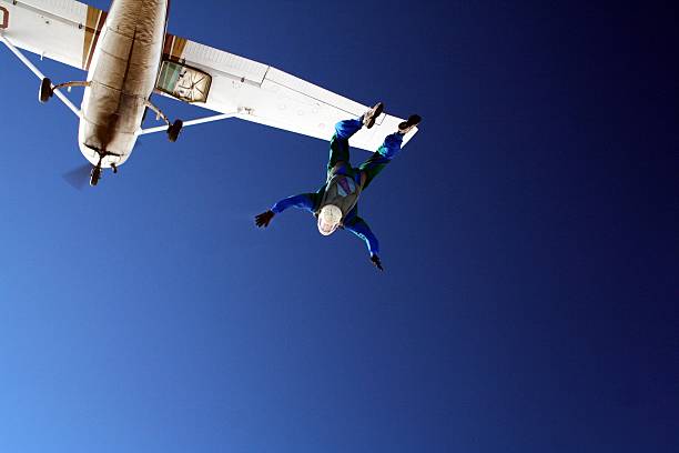 istock Skydiver jumping out of white airplane on clear blue sky 95736246