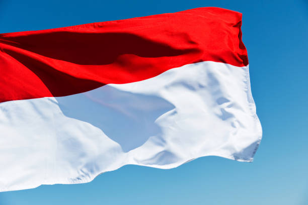 Flag of Indonesia against blue sky.