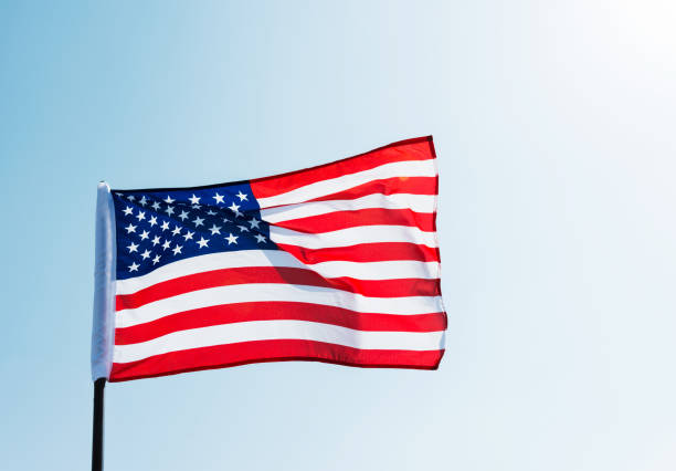 istock American flag waving against blue sky 957364100