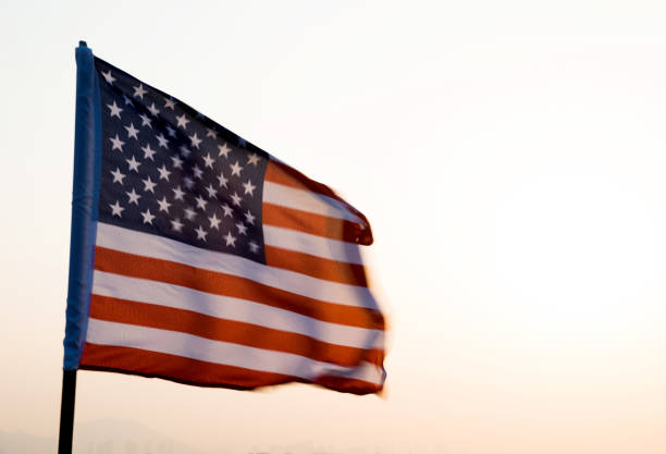 istock American flag waving in sunset 957365392