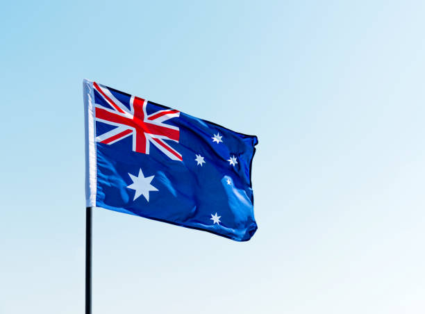 istock Waving Australia flag against blue sky 957365420