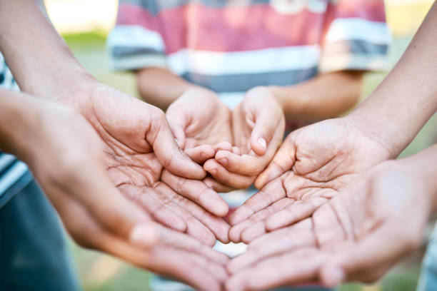 Closeup, couple and holding hands on grass for care with bonding, relax and partnership in backyard of home. People, love and support on lawn in garden of house or park with kindness and relationship