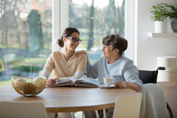 istock Pensioner and nurse sitting together 957369060