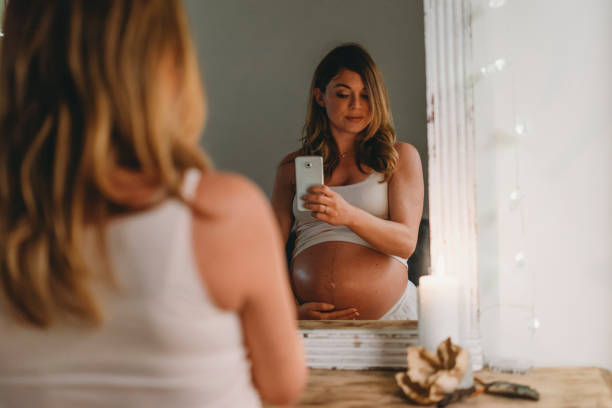 giovane donna incinta adulta a casa - sensuality people mobile phone 30s foto e immagini stock