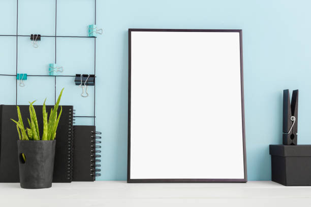 istock Desk with poster frame and blue wall. Mock up. 957372500