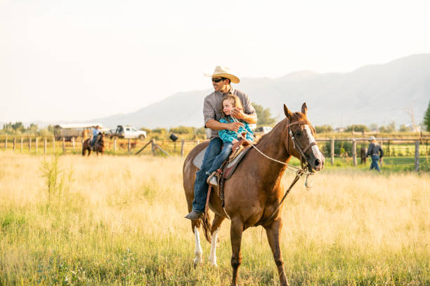 istock Father riding horse with is daughter sat in his lap. 957372652