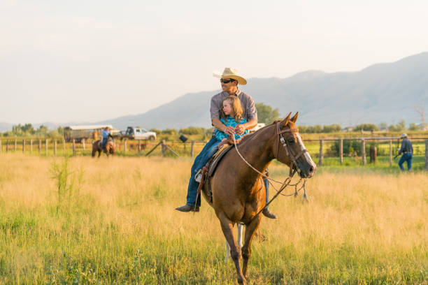 istock Father riding horse with is daughter sat in his lap. 957372722
