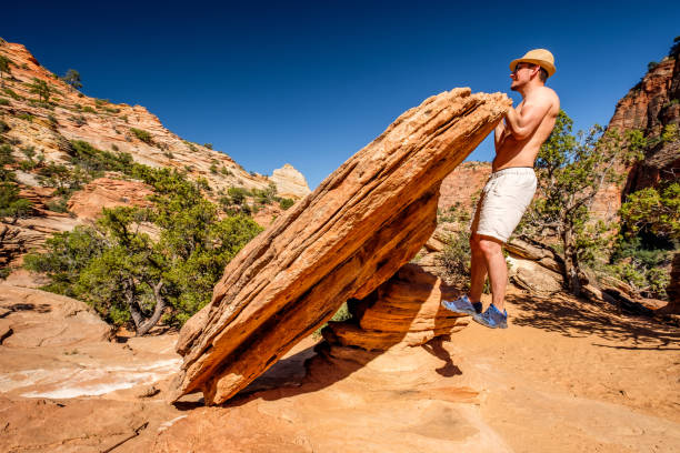 Outdoor work out. Man making pull-ups using rock formation in Zion National Park, Utah, USA