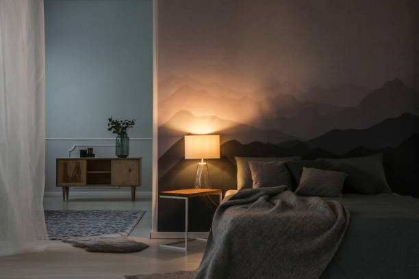Bedroom interior in the night Bedroom interior in the night with warm light of lamp on table near wooden cupboard electric lamp stock pictures, royalty-free photos & images