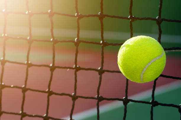 istock Close up tennis ball hitting to net with copy space 957379202
