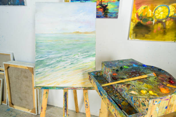 istock canvas on easel and paintings on wall in workshop 957380292