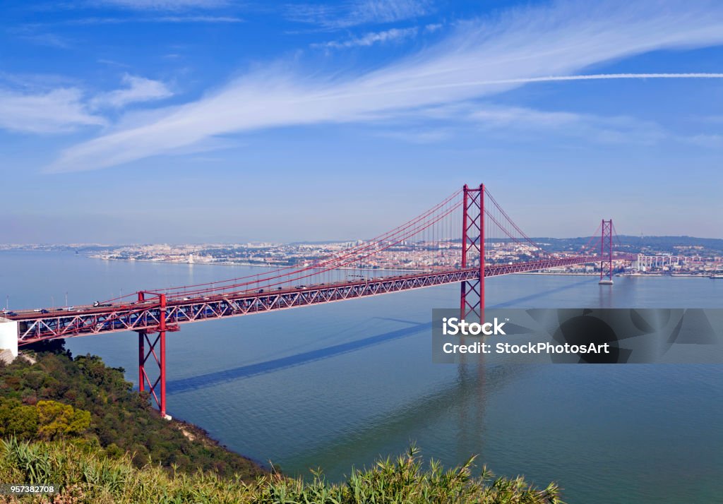 Ponte 25 de Abril Bridge in Lisbon, Portugal. Ponte 25 de Abril Bridge in Lisbon, Portugal. Connects the cities of Lisbon and Almada crossing the Tagus River. View from Almada with Lisbon across the river. Above Stock Photo
