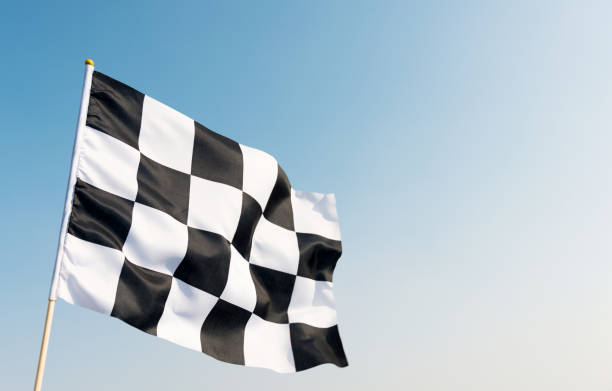 bandera a cuadros volando sobre cielo azul - checkered flag flag auto racing starting line fotografías e imágenes de stock