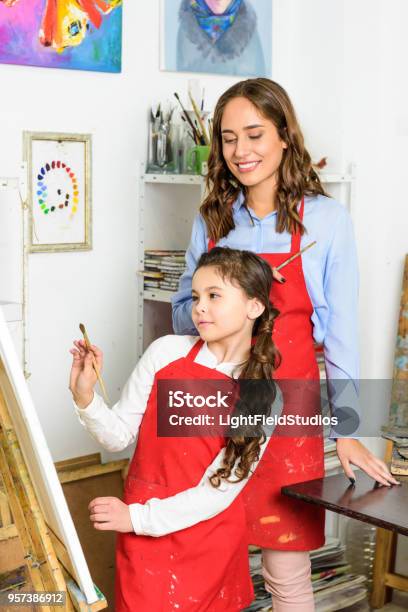 Teacher Watching How Pupil Painting In Workshop Of Art School Stock Photo - Download Image Now