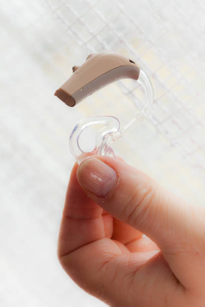 istock senior person holding hearing aid closeup 957388408