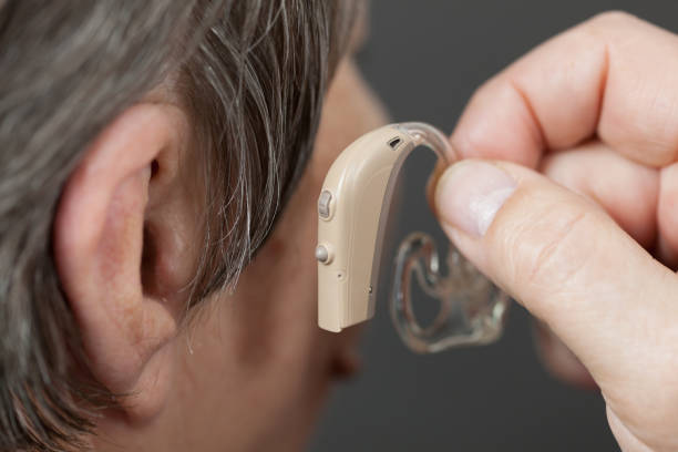 istock Closeup senior woman using hearing aid 957392624